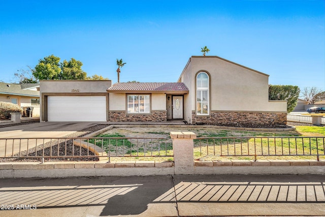 view of front of home with stone siding, a fenced front yard, concrete driveway, and stucco siding