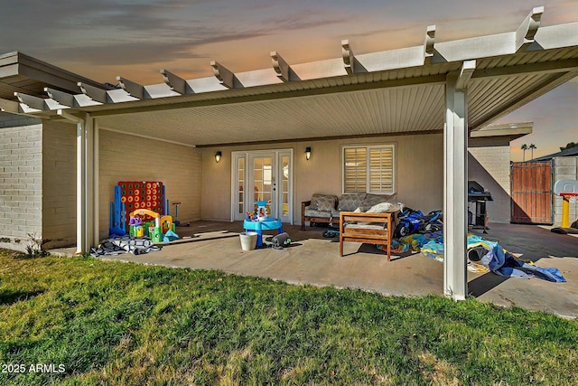 rear view of house with an outdoor hangout area, a patio, brick siding, and a lawn