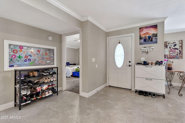 foyer featuring crown molding, baseboards, and light tile patterned floors