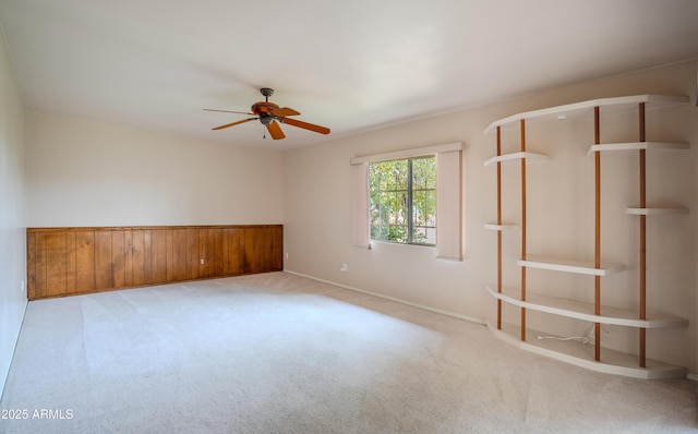 carpeted empty room with a ceiling fan