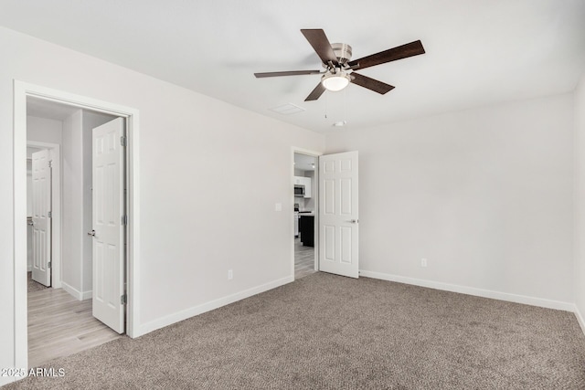 unfurnished bedroom with a ceiling fan, light carpet, and baseboards