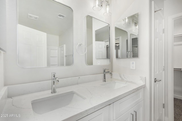 bathroom featuring visible vents, a sink, and double vanity