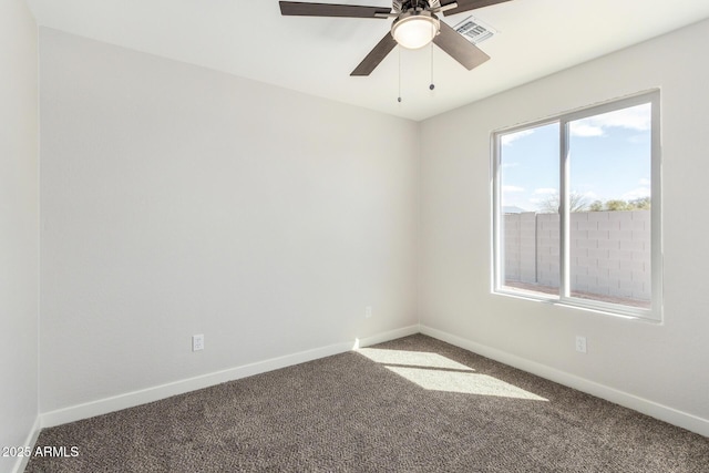 carpeted spare room with baseboards, visible vents, and a ceiling fan