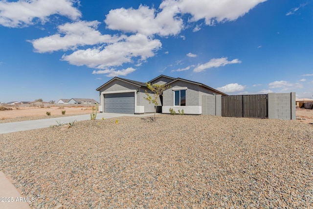 view of front of home with a garage, driveway, a gate, and stucco siding