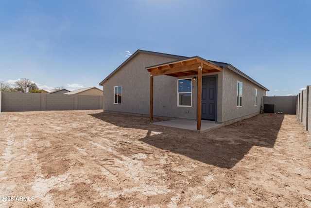 rear view of house with a patio area, a fenced backyard, and stucco siding