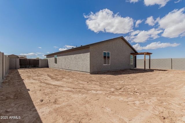 view of side of home featuring a fenced backyard and stucco siding