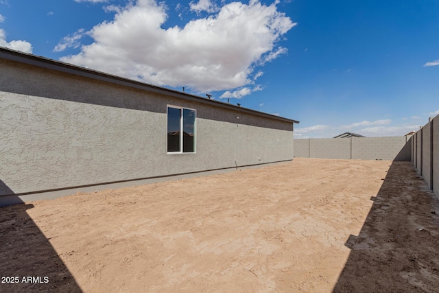 back of house featuring a fenced backyard and stucco siding