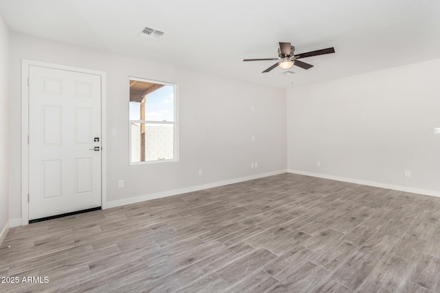 unfurnished room with light wood-style flooring, visible vents, and baseboards