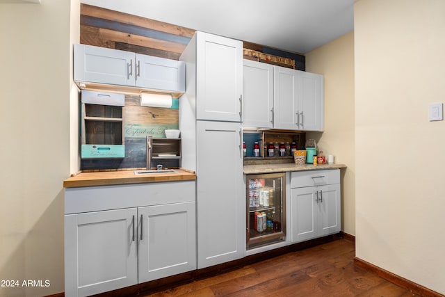 kitchen with wine cooler, dark hardwood / wood-style floors, white cabinetry, and butcher block counters