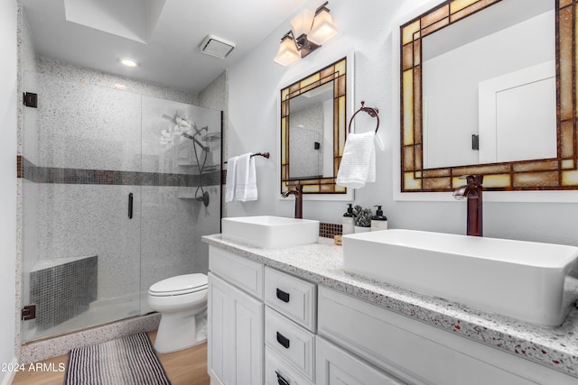 bathroom featuring a shower with shower door, toilet, wood-type flooring, and vanity