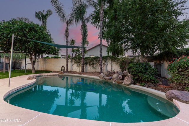 view of pool at dusk