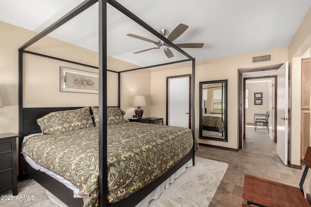 bedroom featuring visible vents, stone finish floor, and a ceiling fan