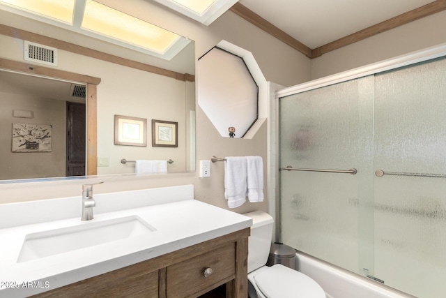 full bath with visible vents, vanity, toilet, and bath / shower combo with glass door