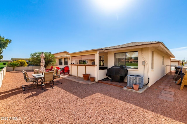 rear view of house featuring a patio area, central AC, a fenced backyard, and stucco siding