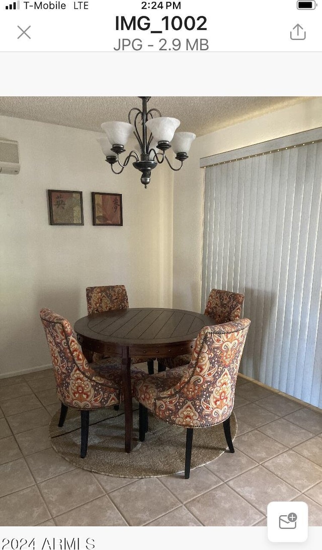 tiled dining space with a wall mounted air conditioner, a textured ceiling, and a chandelier