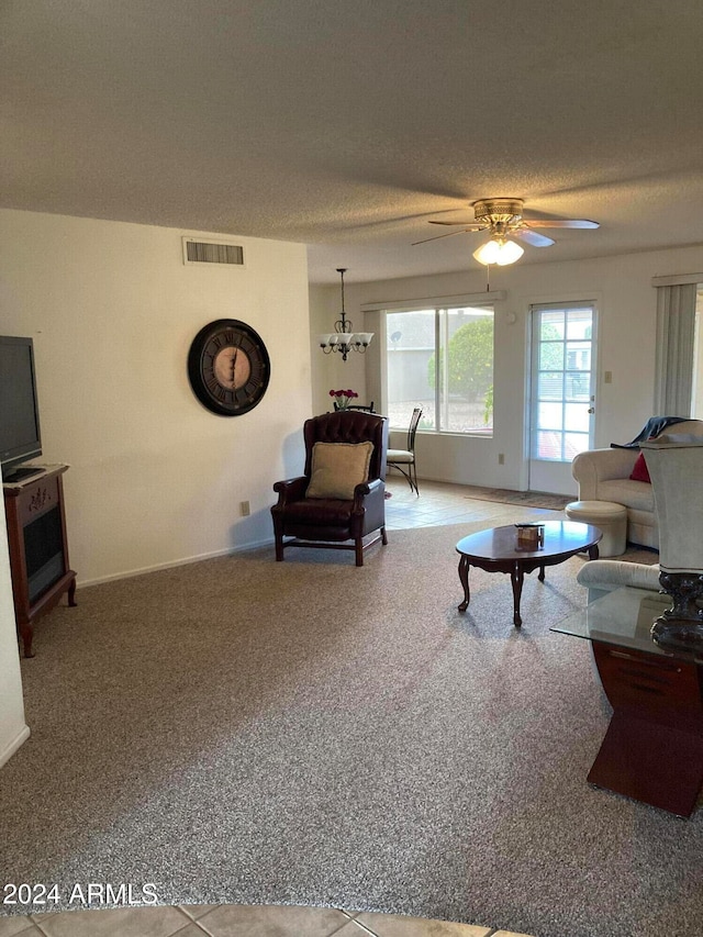 living room with a textured ceiling and ceiling fan with notable chandelier