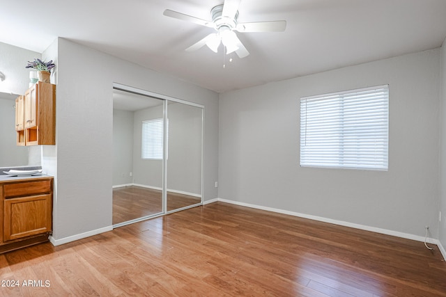 unfurnished bedroom featuring ceiling fan, a closet, and light hardwood / wood-style floors