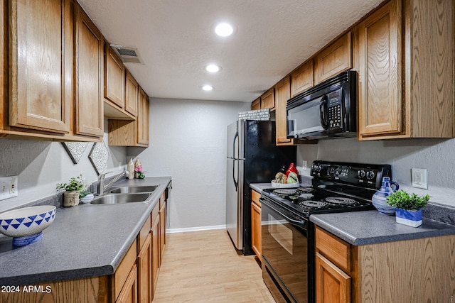 kitchen featuring a textured ceiling, light hardwood / wood-style flooring, sink, and black appliances