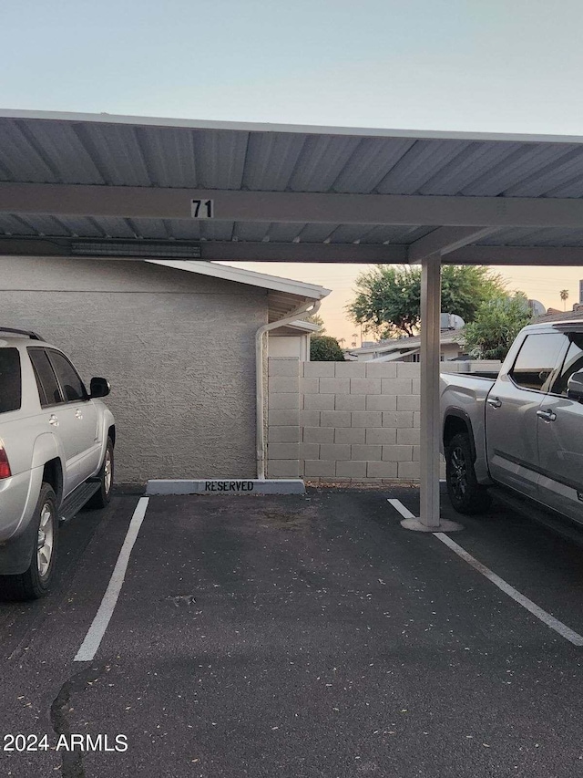 parking at dusk featuring a carport