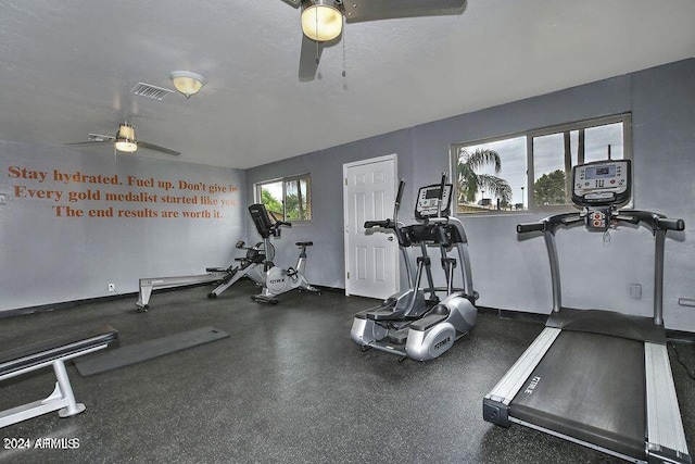 workout area with ceiling fan and a textured ceiling