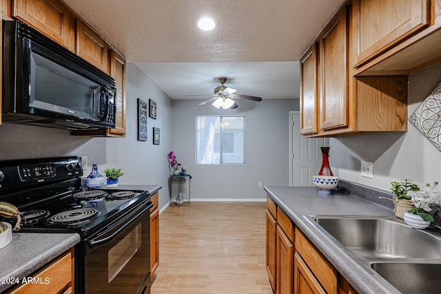 kitchen featuring ceiling fan, sink, a textured ceiling, black appliances, and light hardwood / wood-style floors