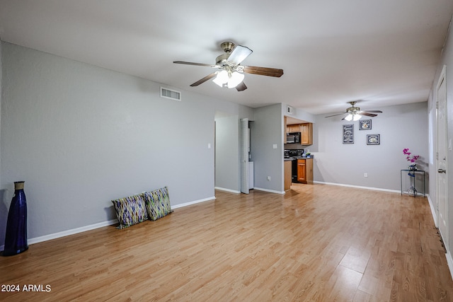 unfurnished living room featuring ceiling fan and light hardwood / wood-style flooring