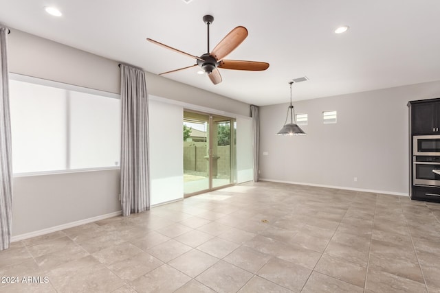 tiled spare room with ceiling fan