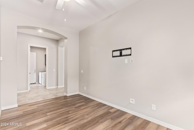 spare room with light wood-type flooring, ceiling fan, and washing machine and clothes dryer