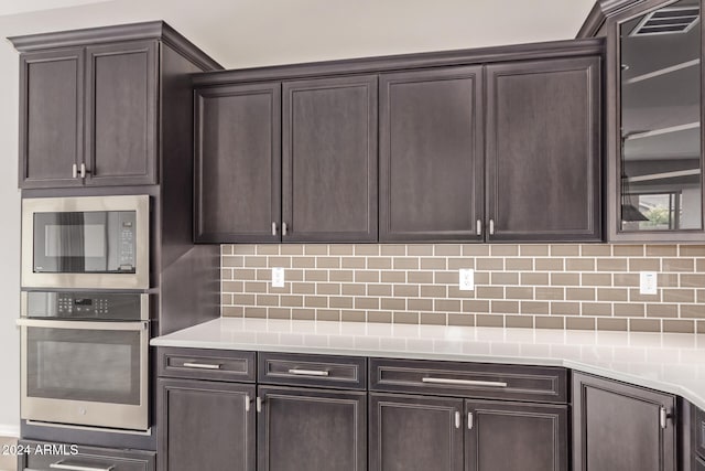 kitchen featuring dark brown cabinets, stainless steel appliances, and tasteful backsplash