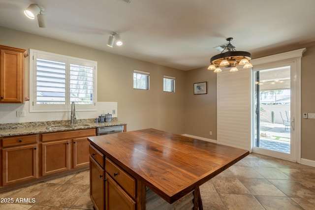 kitchen with a sink, butcher block countertops, brown cabinets, and decorative backsplash