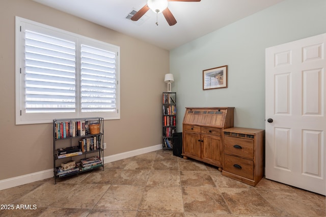 misc room featuring ceiling fan, light stone finish floors, and baseboards