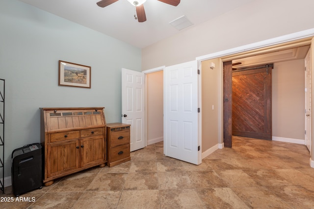 bedroom with stone finish floors, baseboards, and a ceiling fan
