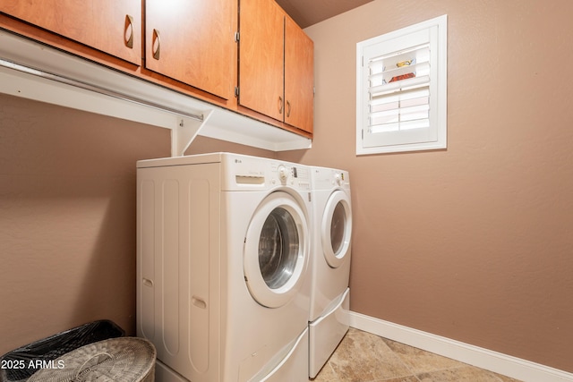 laundry area featuring cabinet space, independent washer and dryer, and baseboards