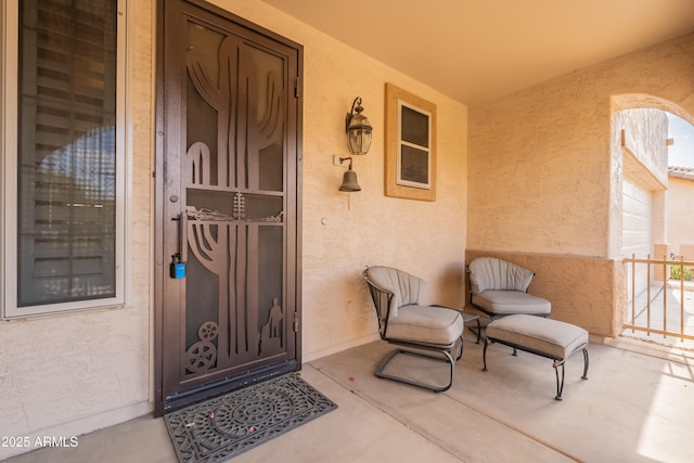 doorway to property with stucco siding and covered porch