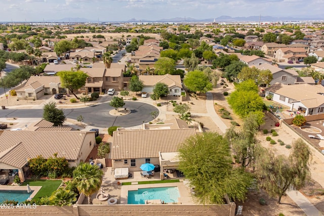 aerial perspective of suburban area with mountains and a pool