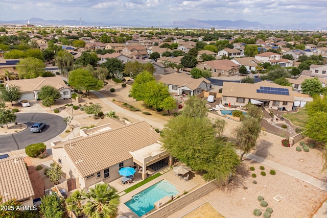 aerial perspective of suburban area featuring a pool area and a mountainous background