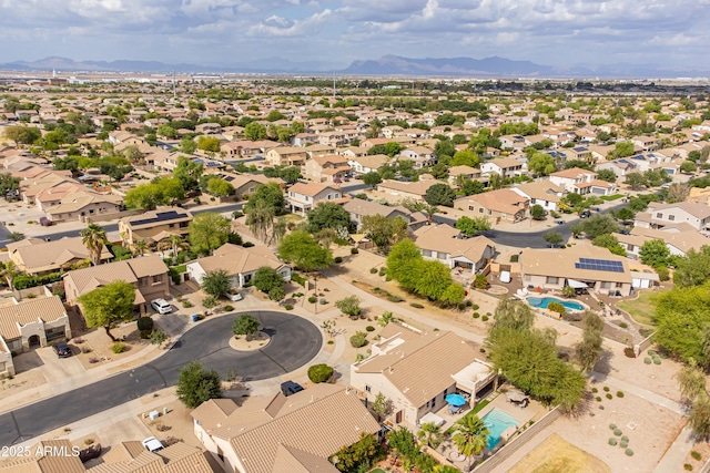 aerial view of residential area with a mountain backdrop and a pool