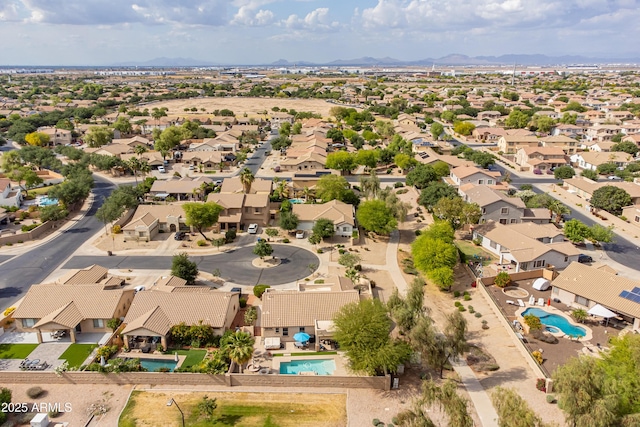 aerial view of residential area with a pool area and a mountainous background