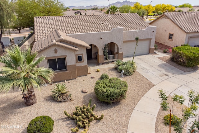 view of front of property featuring stucco siding, a garage, a tile roof, and concrete driveway