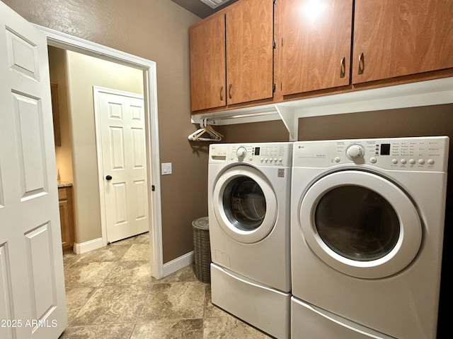 washroom featuring cabinet space, independent washer and dryer, and baseboards