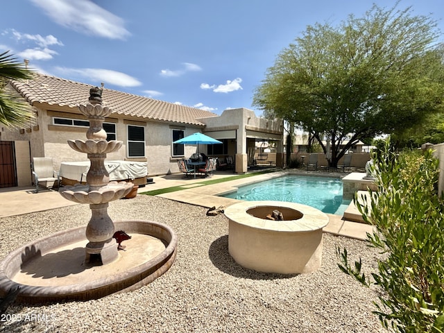 view of swimming pool featuring a patio area, an outdoor fire pit, and a fenced backyard
