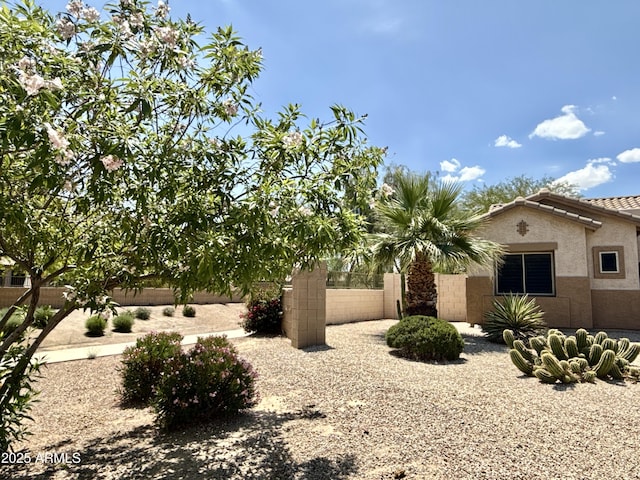 view of home's exterior featuring fence, stucco siding, and a tile roof