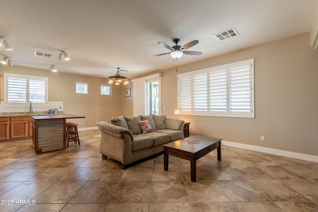 living room with baseboards and ceiling fan