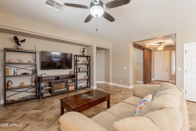 living area featuring ceiling fan, baseboards, and stone finish flooring