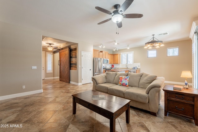 living area featuring a ceiling fan and baseboards
