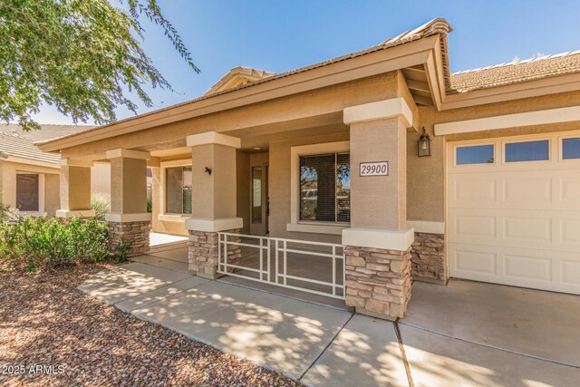 29900 N Maravilla Dr, San Tan Valley, AZ 85143 - doorway to property featuring stone siding, stucco siding, a porch, and a garage