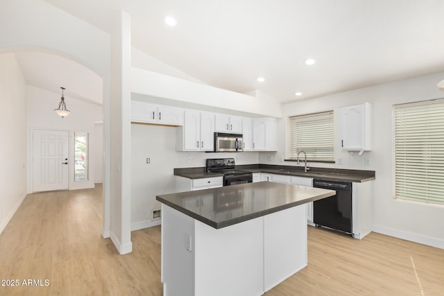 29900 N Maravilla Dr, San Tan Valley, AZ 85143 - kitchen with dark countertops, black appliances, light wood-type flooring, white cabinetry, and a sink