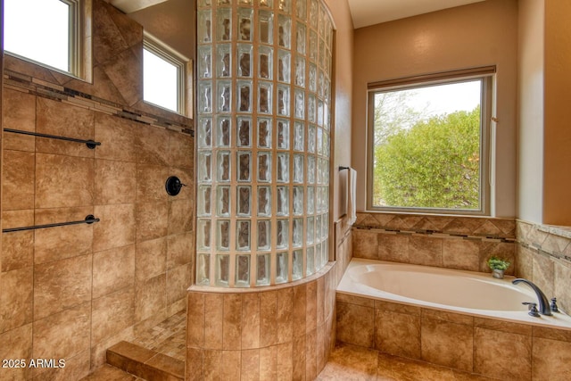 bathroom with a walk in shower, a bath, and a wealth of natural light
