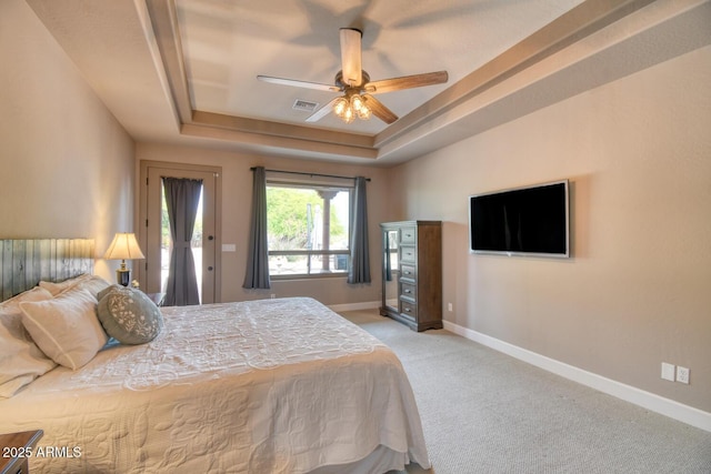 bedroom with visible vents, baseboards, access to outside, light colored carpet, and a tray ceiling