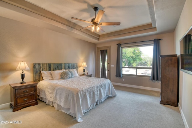 bedroom with baseboards, access to outside, a tray ceiling, and light colored carpet